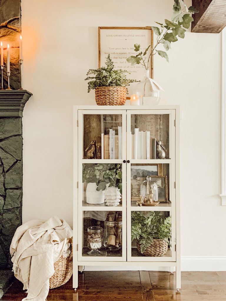 Living room cabinet with decorated shelves for cozy home decor. 