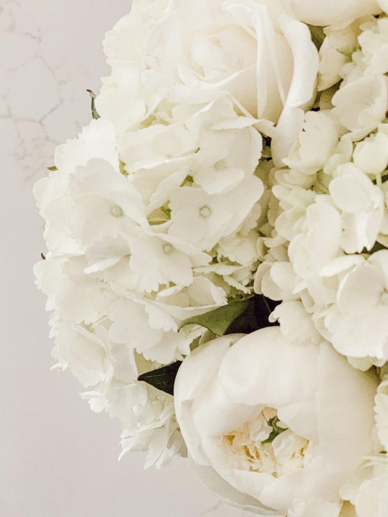 A flower arrangement full of fresh white spring flowers.