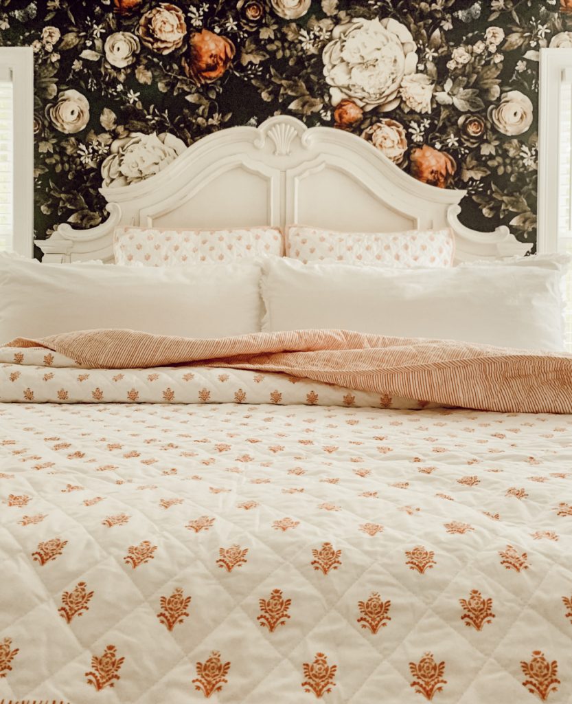 Farmhouse bedroom with floral wallpaper.