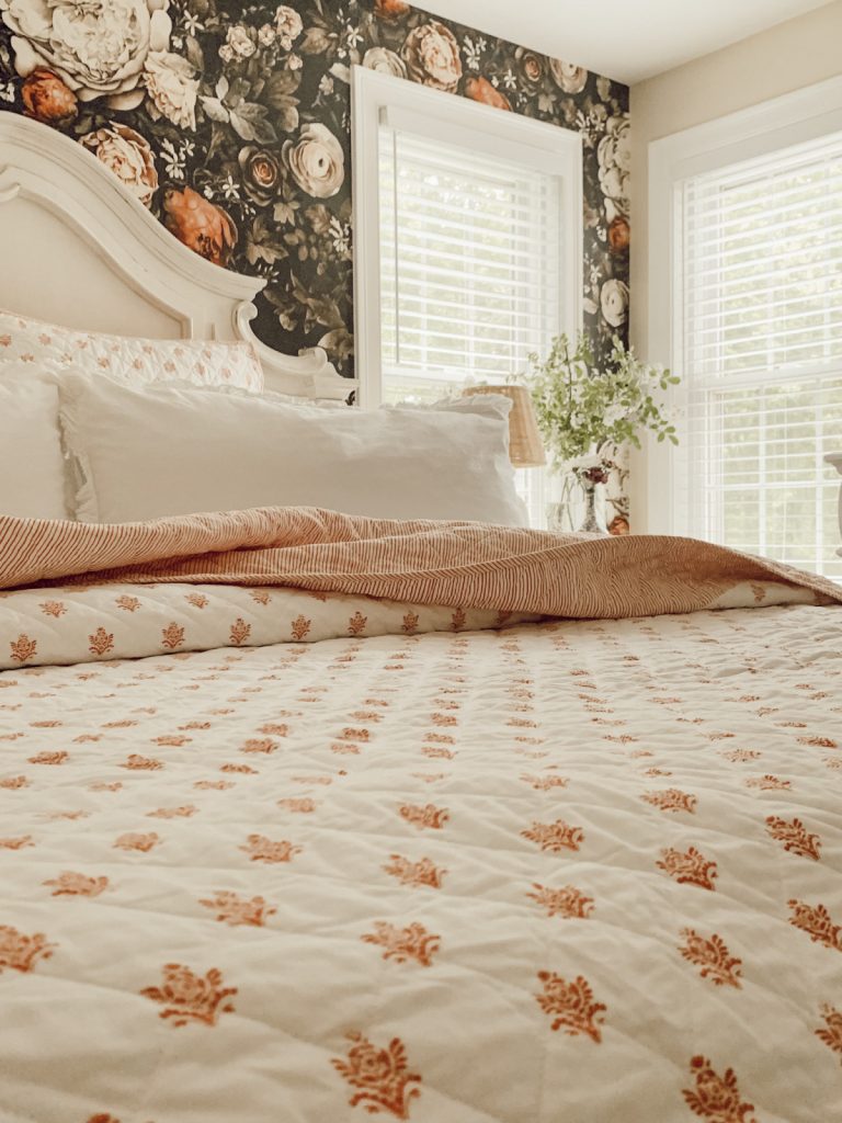 Summer home with quilts, fresh flowers, and no curtains.