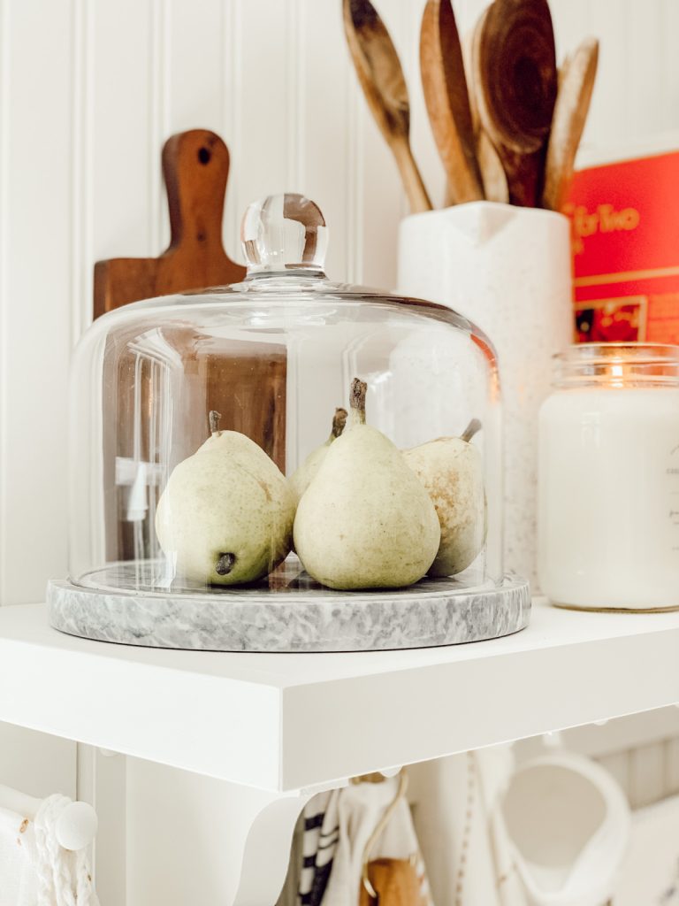 Natural elements are key to cozy kitchen shelf styling.