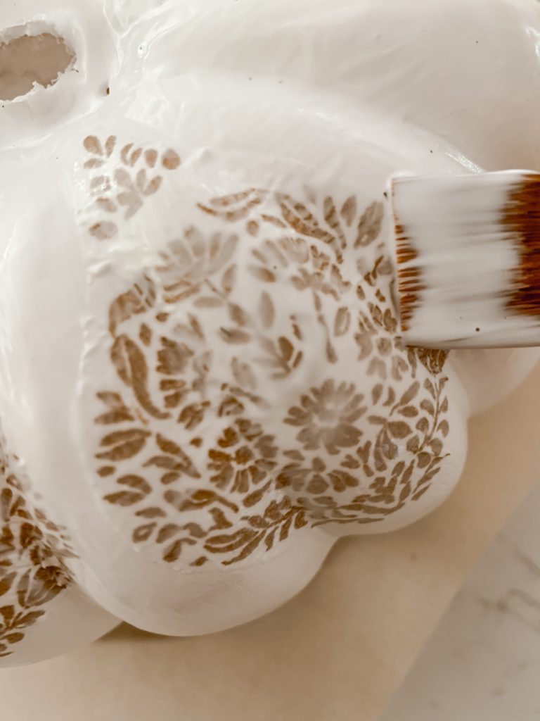 Applying Mod Podge on pumpkin to create a decoupaged gourd.