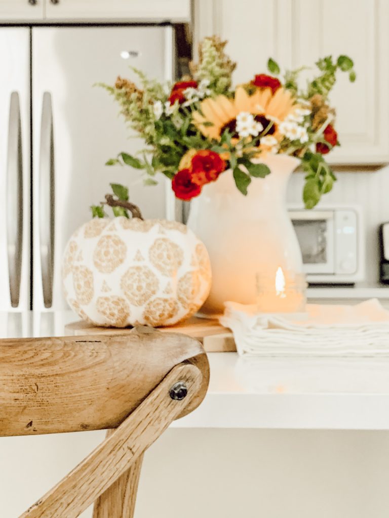 Decoupage pumpkin with decorative paper napkins on kitchen counter.