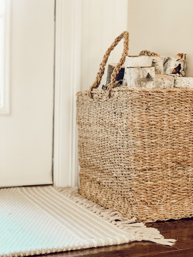 A basket filled with firewood next to the entrance of our home. 