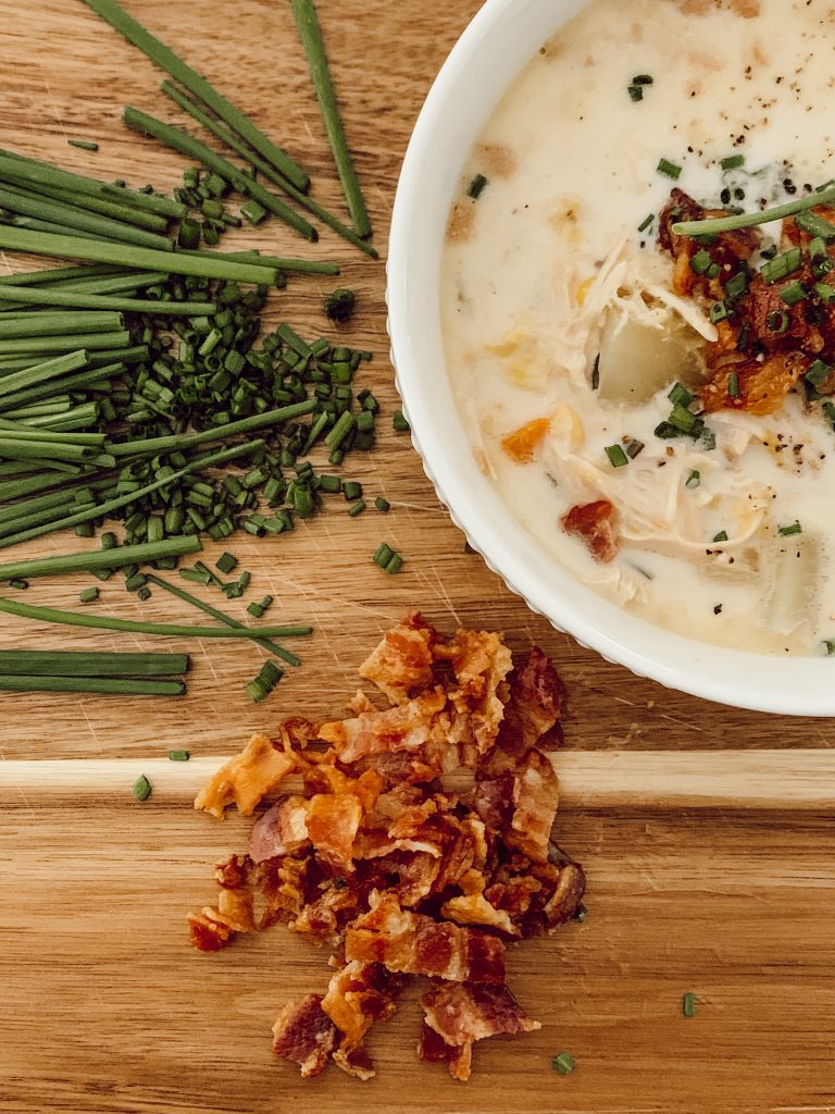 Creamy chicken corn chowder garnished with smoky bacon and chives.