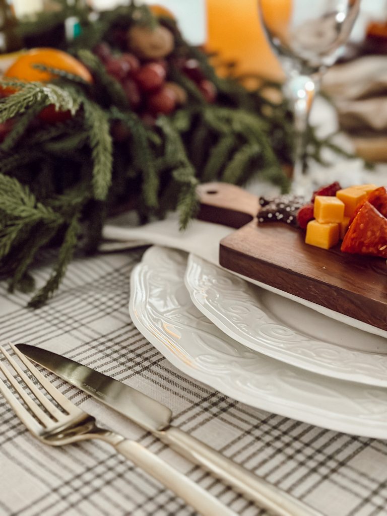 A small board with assorted meats, cheeses, fresh fruit, and cookies.