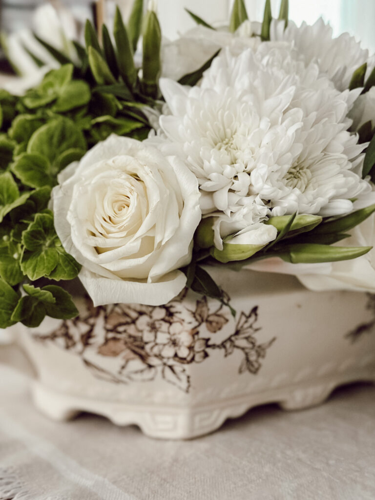 Using a vintage soup tureen filled with fresh flowers as a table centerpiece.
