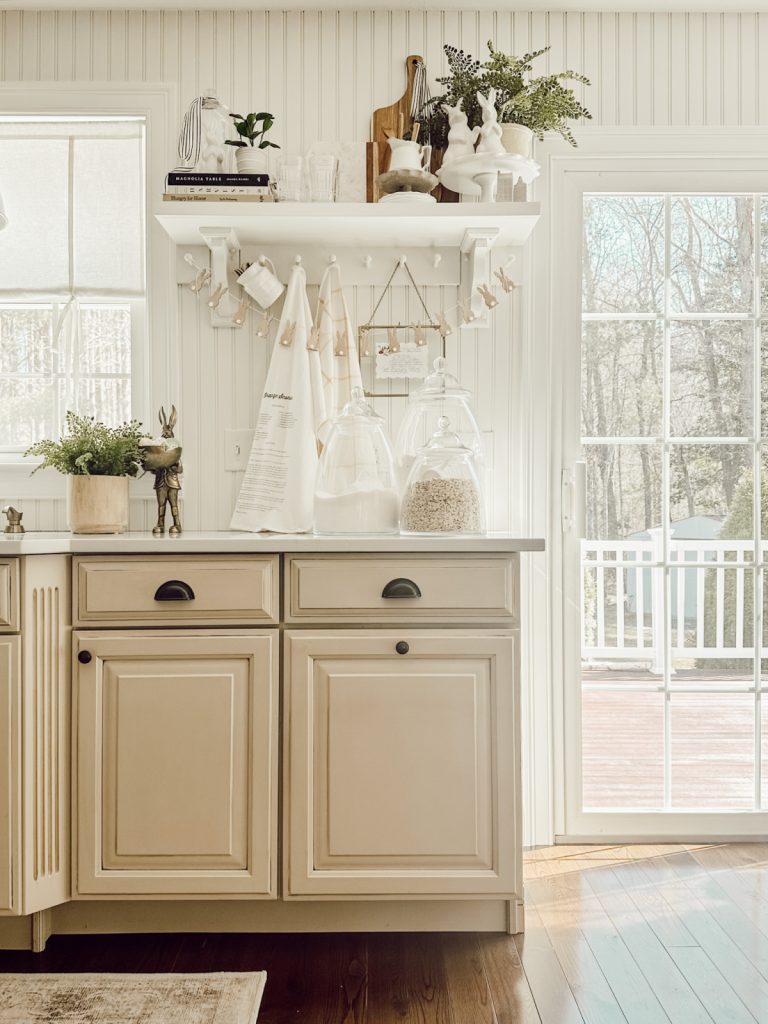 Cozy farmhouse kitchen decorated for spring with greenery & neutral colors.