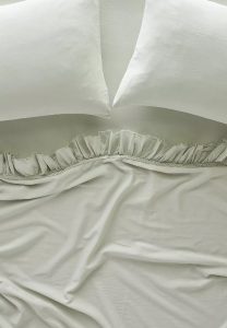 Green cotton ruffled sheets for a cozy French country bedroom.