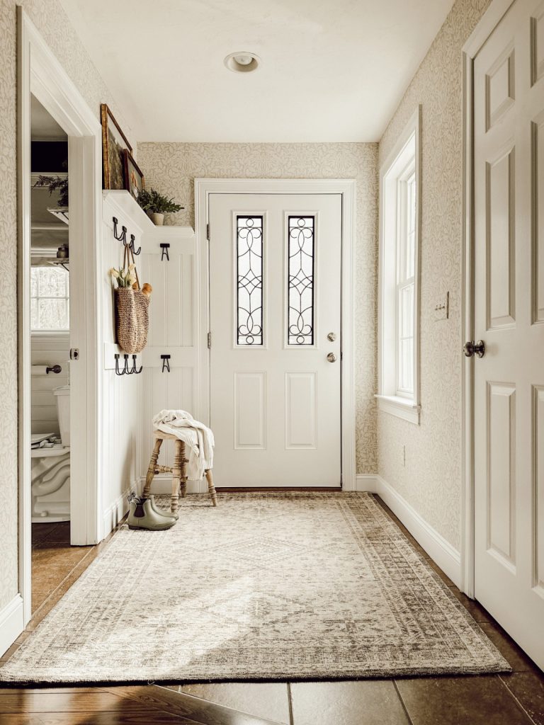 Cozy farmhouse entryway styled for spring with yellow tulips.