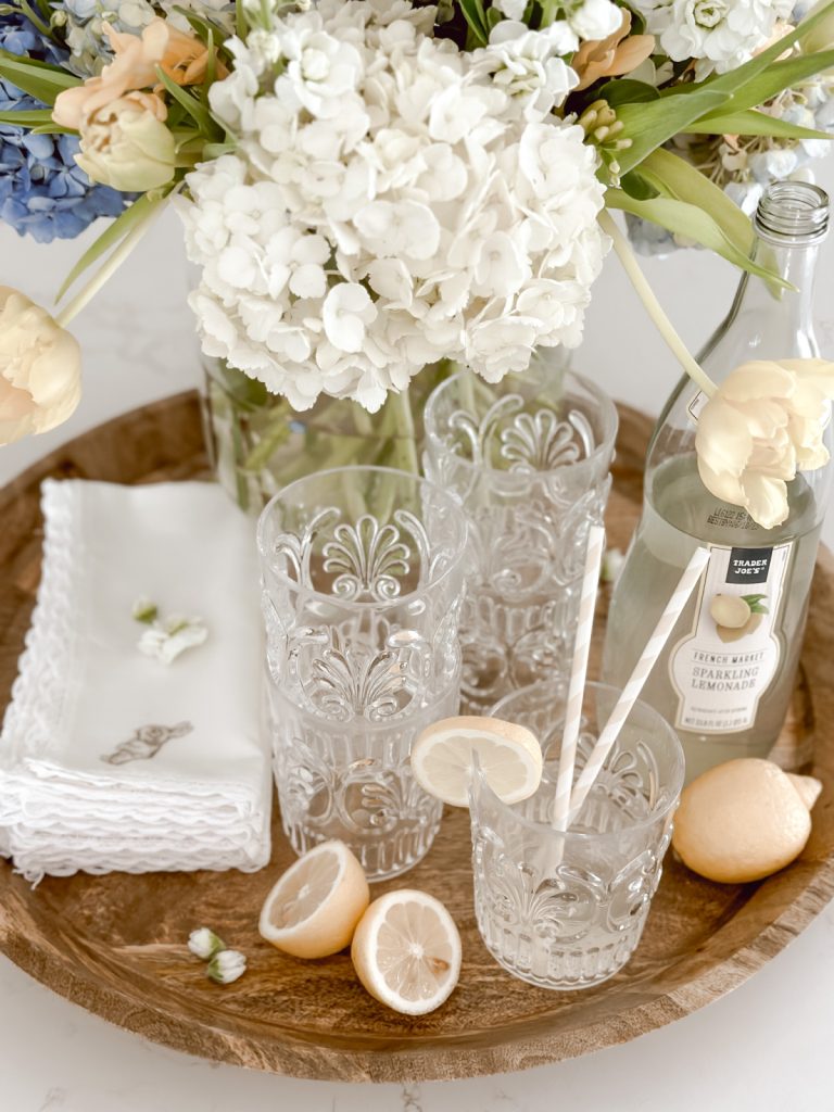 A spring centerpiece that includes fresh flowers, lemons, & lemonade.