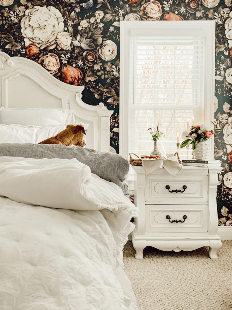 French country primary bedroom with floral wallpaper & spring bedding.