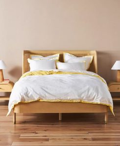 White bedding with yellow accents for a cozy bedroom.