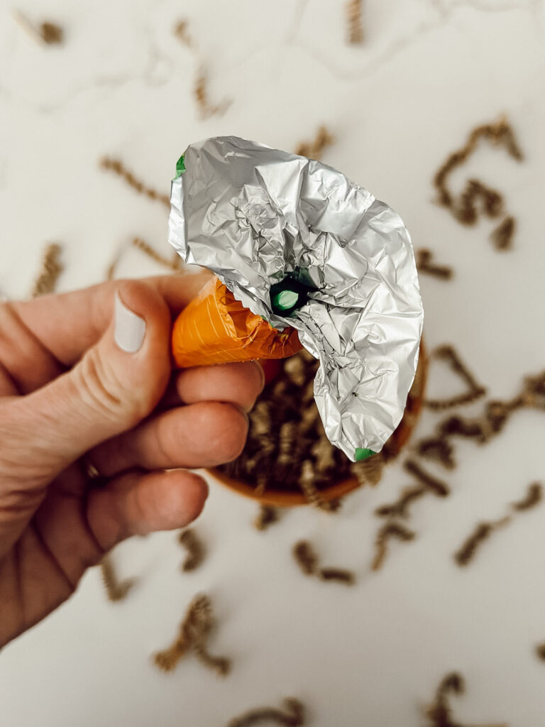 Break off the plastic stem inside the Lindt carrot chocolate candy before placing inside of the flower pot.