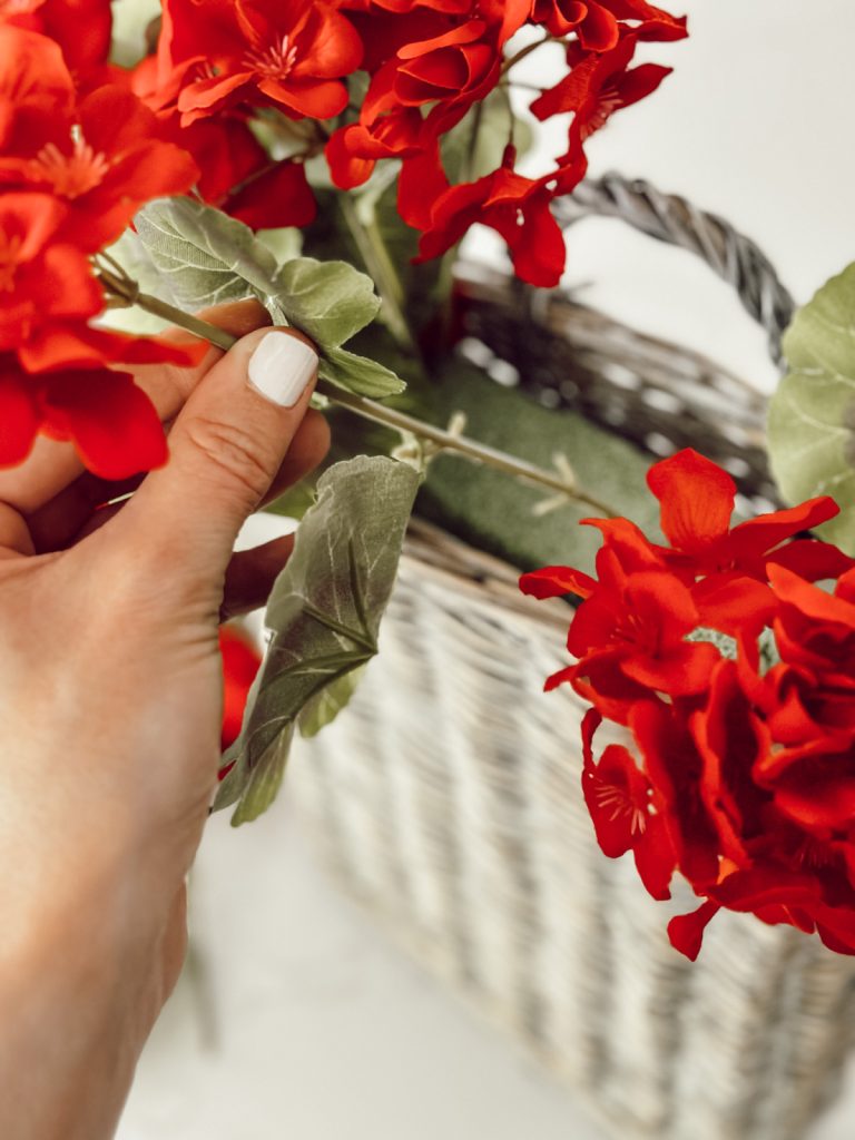Insert red geraniums into floral foam filled door basket for summer.