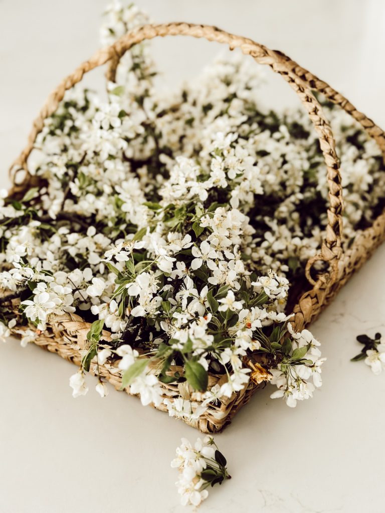 Flowers in a farmhouse woven vessel on a the kitchen counter. 