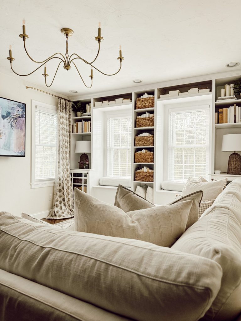 Neutral farmhouse living room with built in bookshelves.