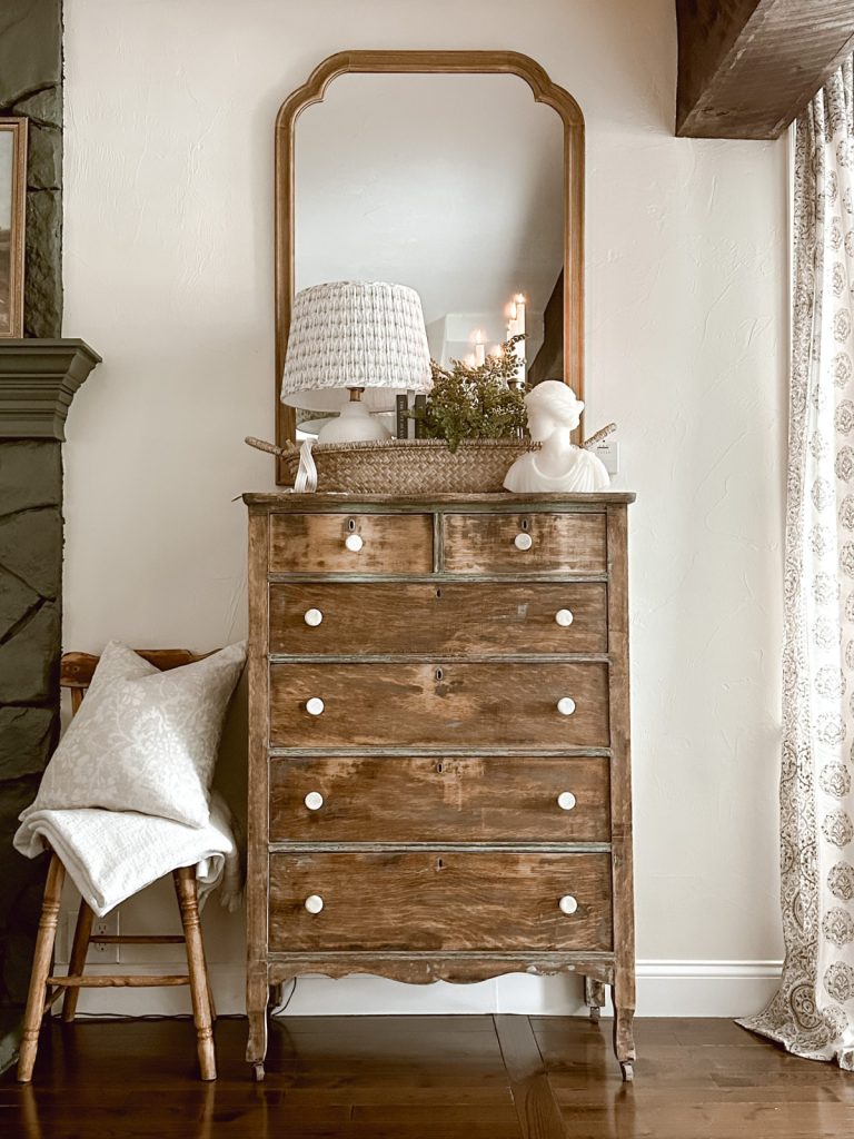 A rustic farmhouse-style living room decorated with a vignette corralled by a basket.