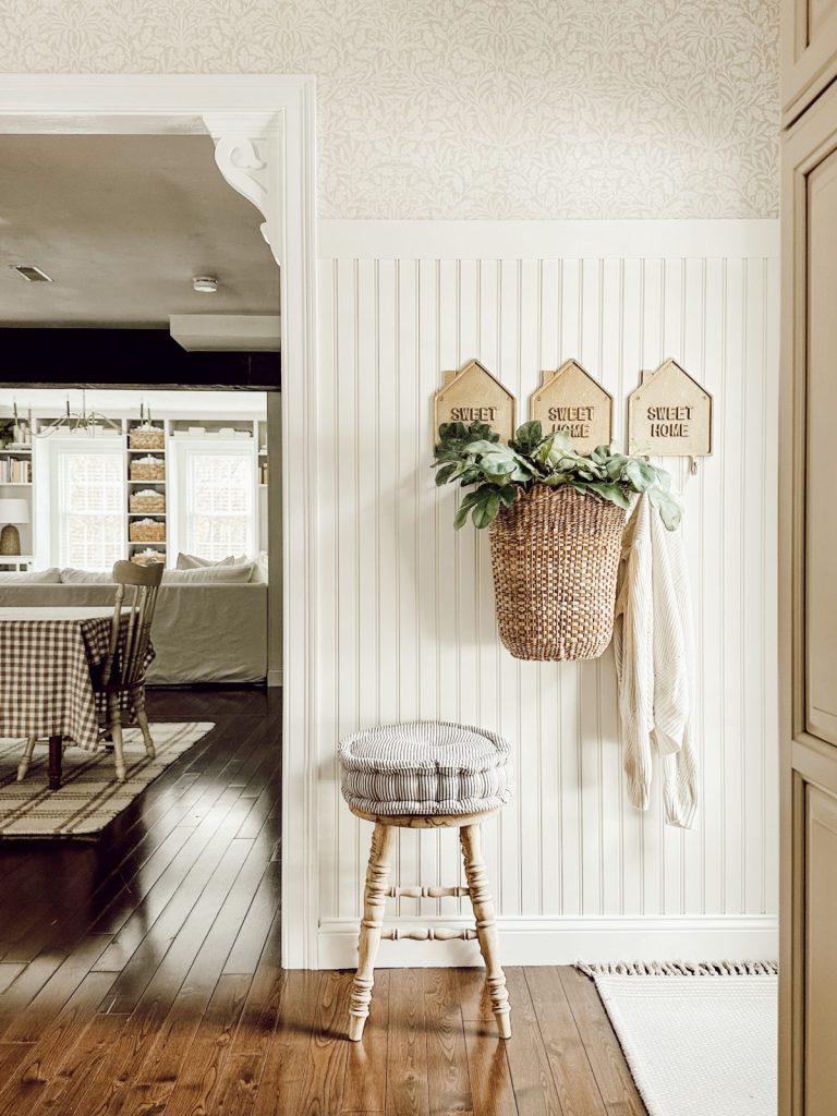 An entrance decorated with a rustic container filled with vibrant greenery, adding warmth and texture to the decor.