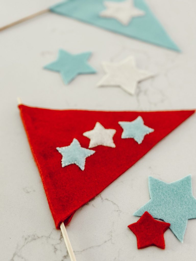 Homemade patriotic felt flags with red, white, and blue colors.