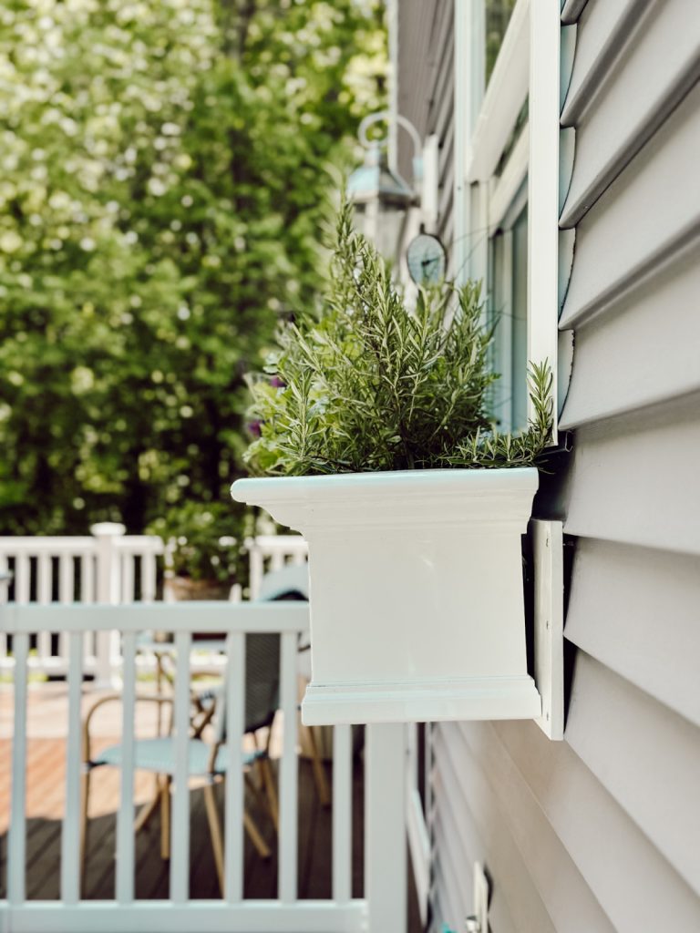 Summer views in New England with a planter filled with herbs.