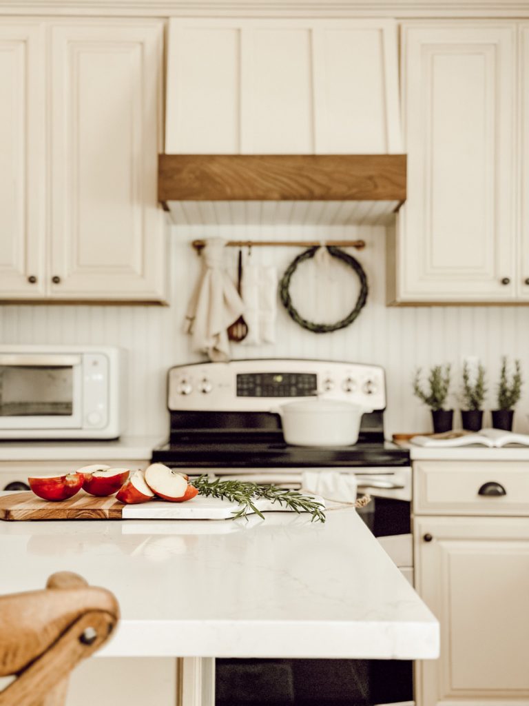 Apples and rosemary in a neutral farmhouse kitchen.