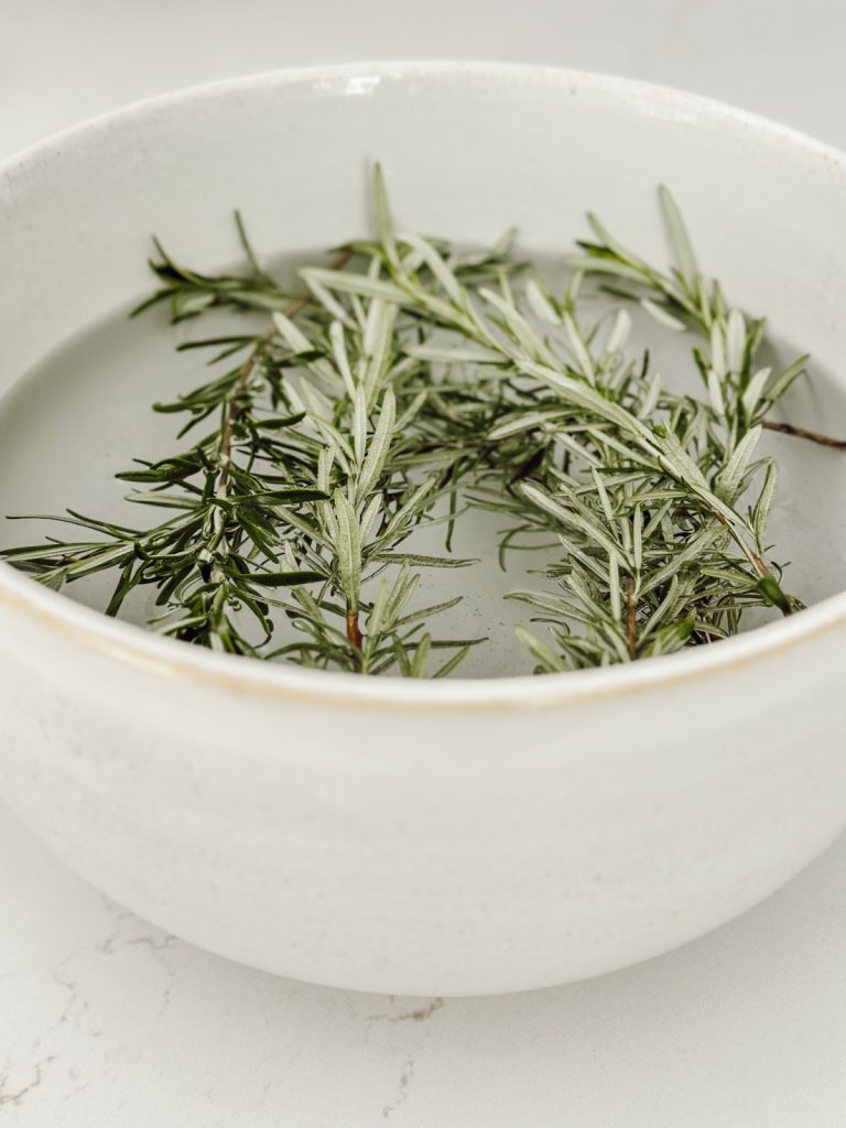 Soak fresh rosemary in water before adding to the DIY herb wreath.