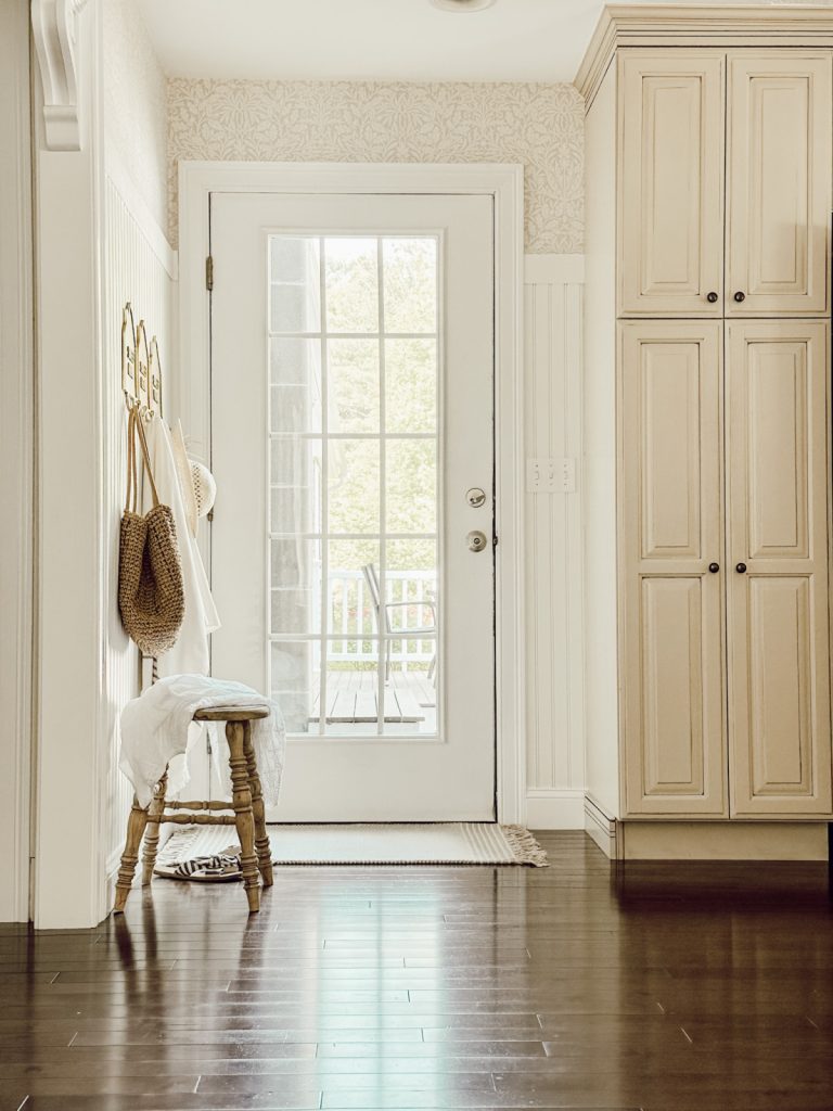 Farmhouse entryway with glass door and neutral colors.