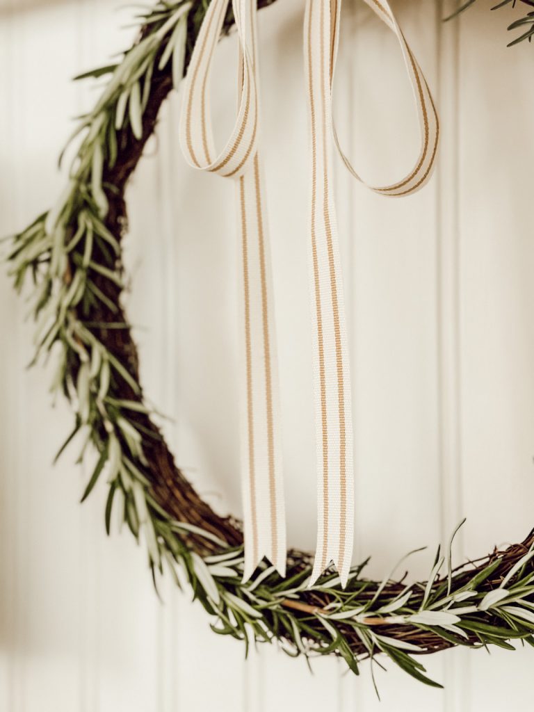 Ticking stripe ribbon on wreath made with fresh herbs.