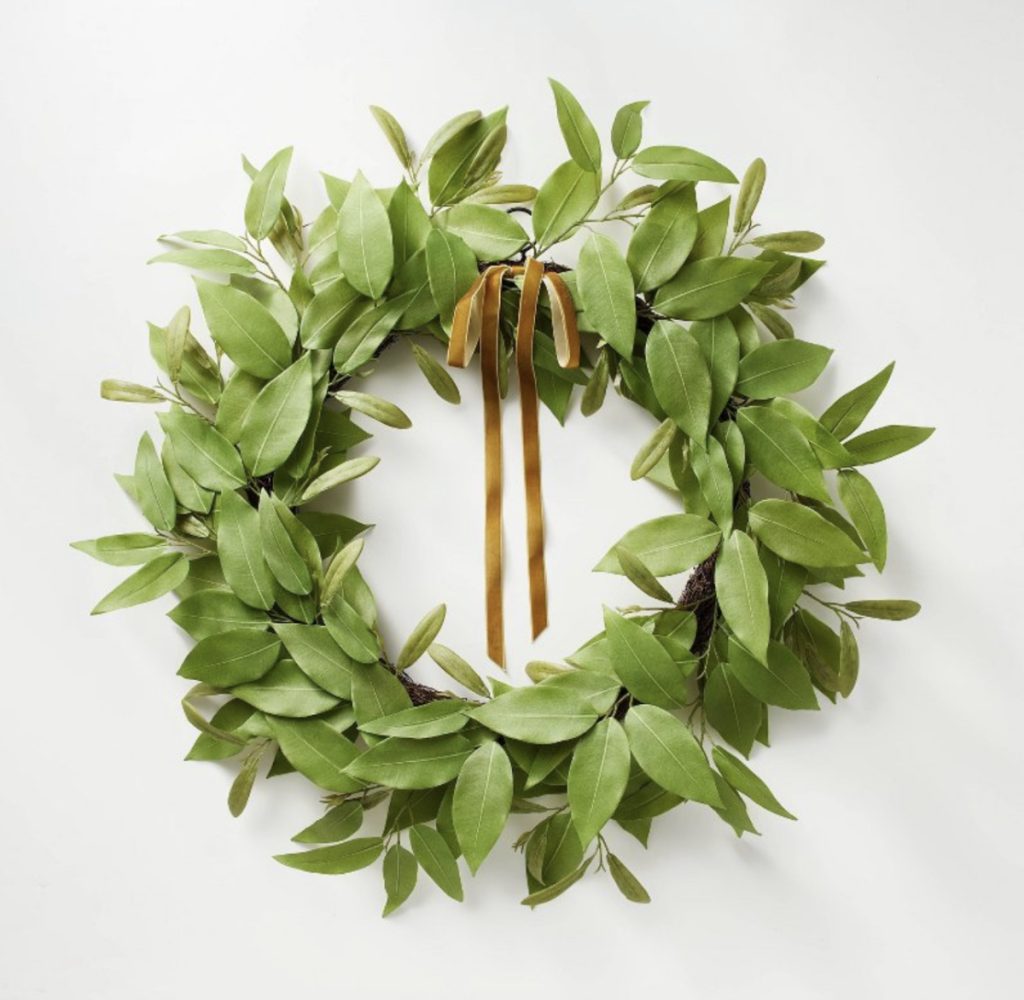 Green wreath with brown ribbon for a farmhouse home.