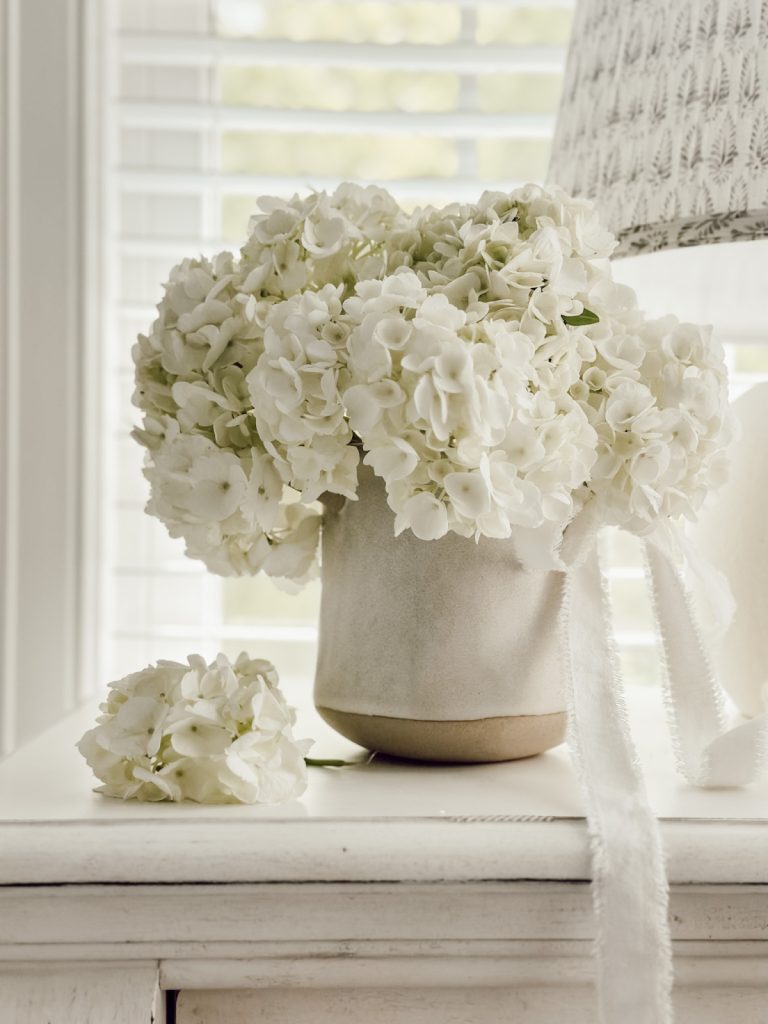 Fresh hydrangeas in a small bedroom is a great way to decorate on a budget.