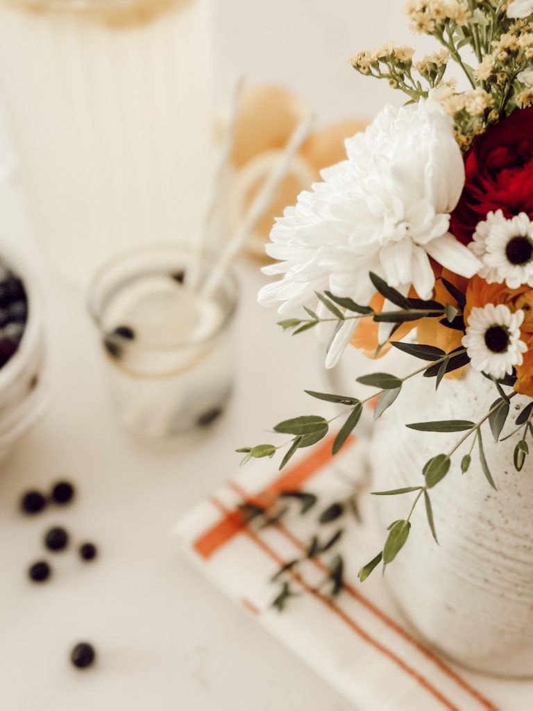 Decor in a functional kitchen for summer with lemonade and flowers.