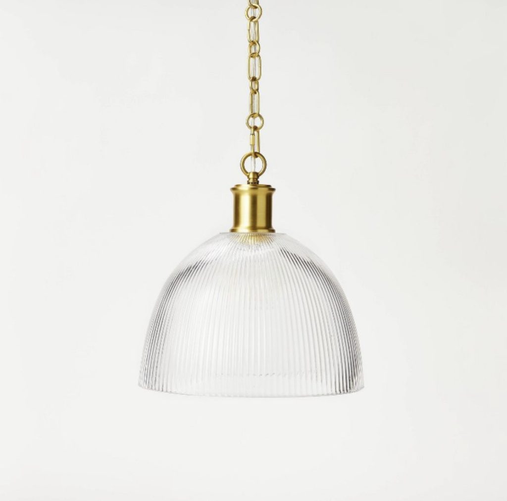 Glass pendant light for the kitchen with a gold chain.