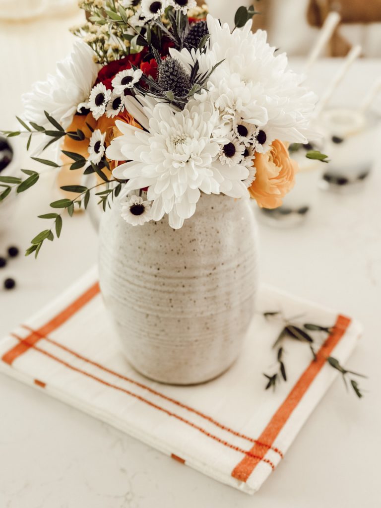 Pitcher of fresh flowers in a cottage farmhouse kitchen styled for summer.