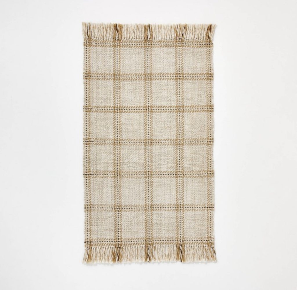 Plaid throw rug for the entrance of a home that will add coziness. 