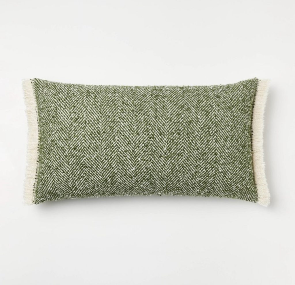 Herringbone lumbar pillow in green with cream fringe.