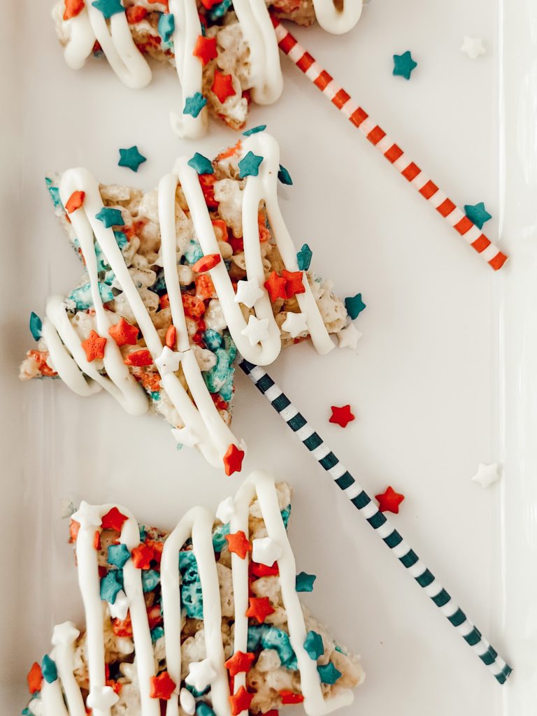 Fourth of July Rice Krispie treats with white chocolate drizzle and patriotic sprinkles.