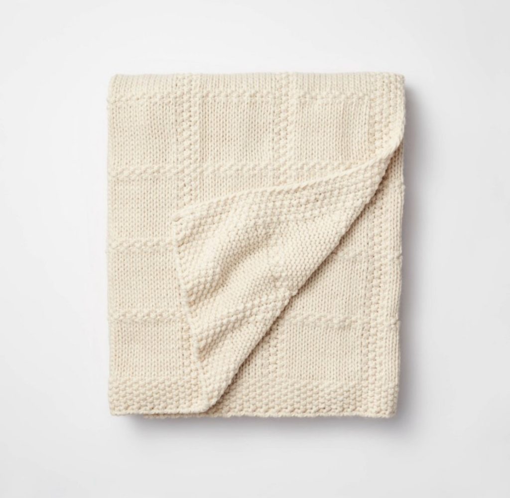 Cream knit blanket for cuddling on the couch or in bed.