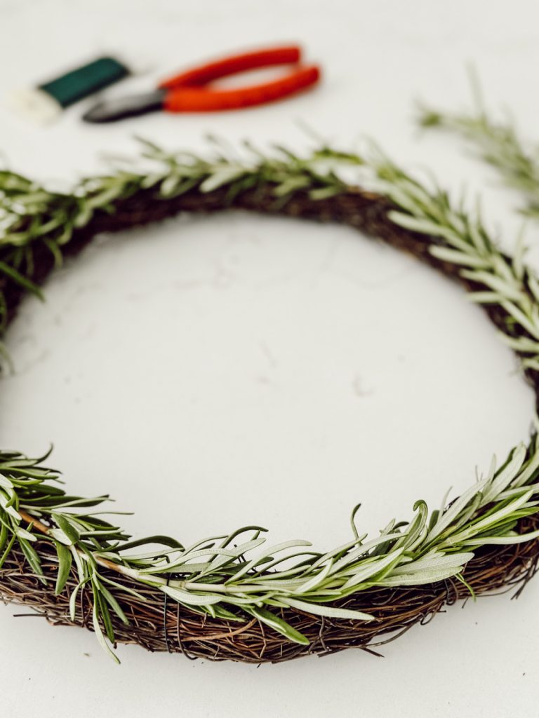 DIY rosemary wreath with fresh herbs, florist wire, and pliers.