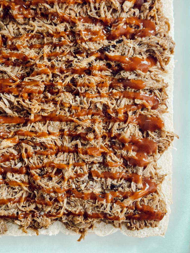 Barbecue pork on slider rolls drizzled with more BBQ sauce.