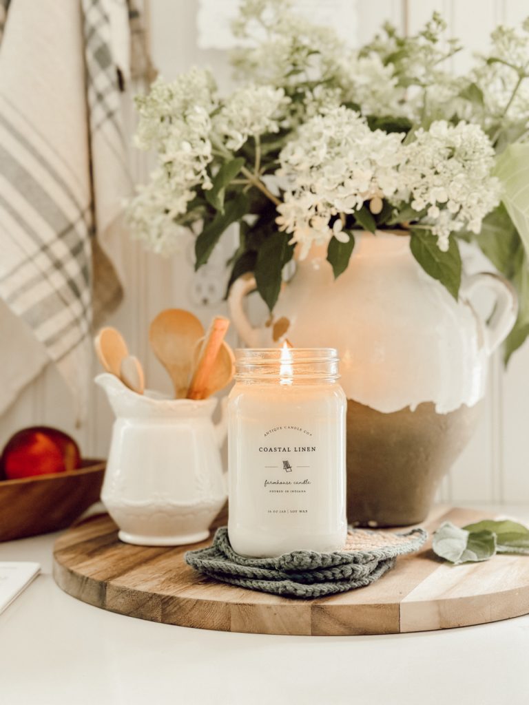 Kitchen counter vignette with a vase, ironstone pitcher, and candle.