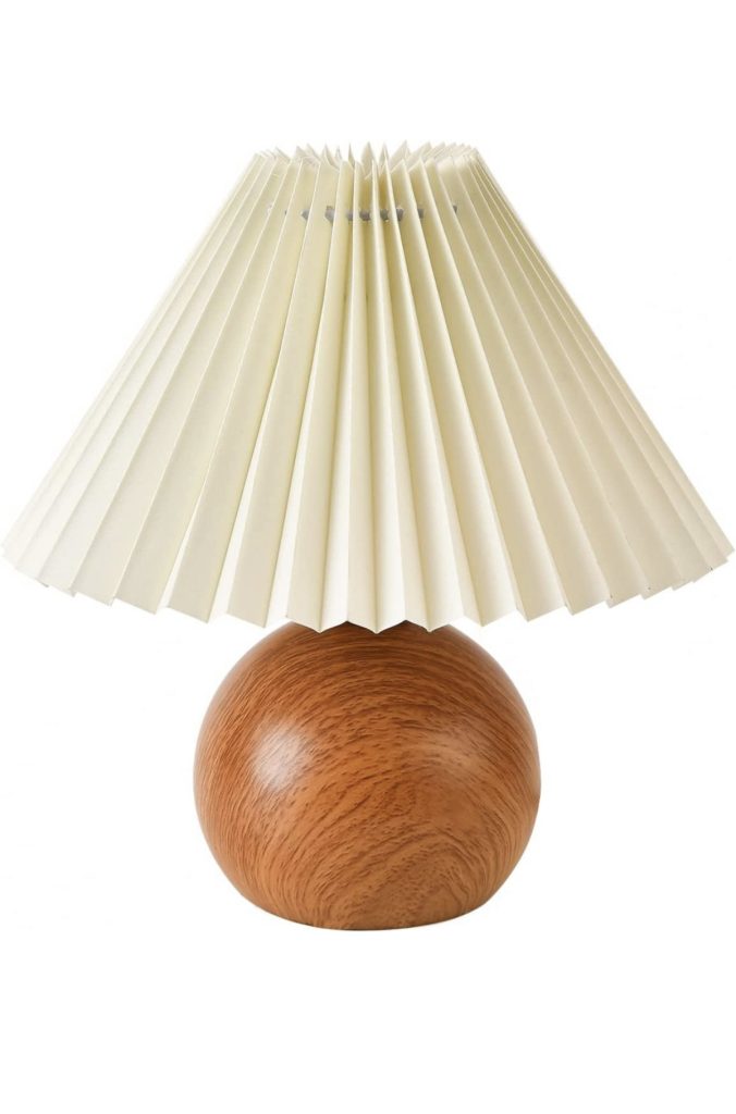 Wooden lamp base with cream colored pleated lampshade.