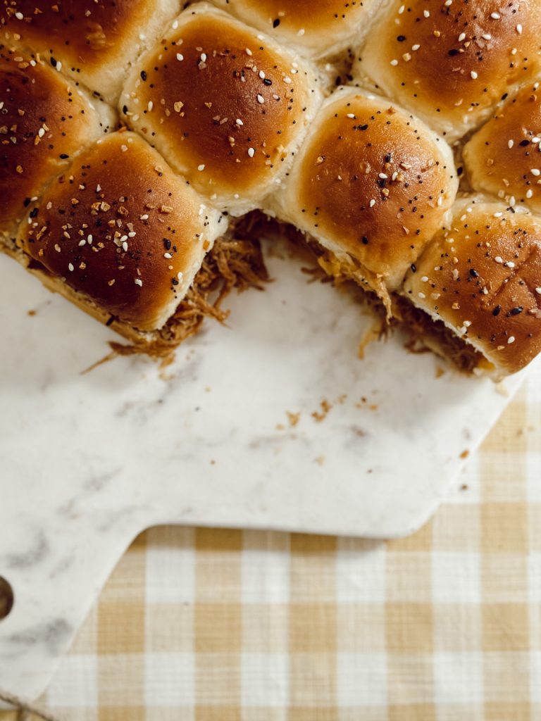 Summer cookout recipe with pulled pork, slider rolls, cheese, and barbecue sauce.