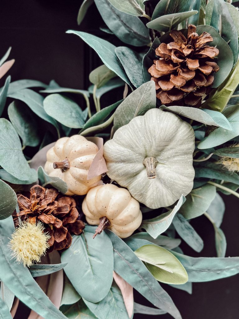 Adorable fall DIY wreath with pumpkins, pinecones, and eucalyptus.