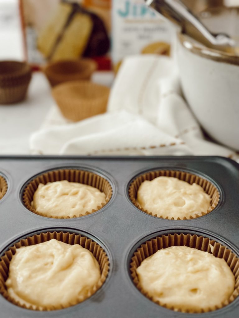Jiffy cornbread cake mix batter in lined muffin pan.