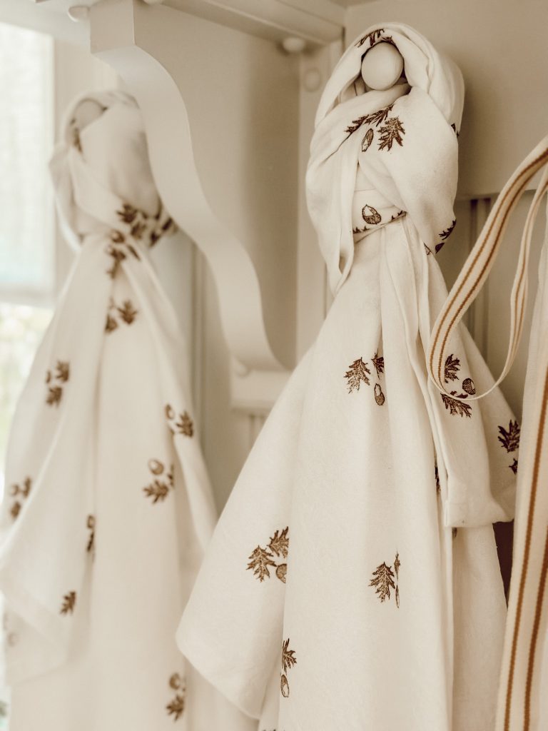 Hanging kitchen towels on hooks for easy kitchen use.