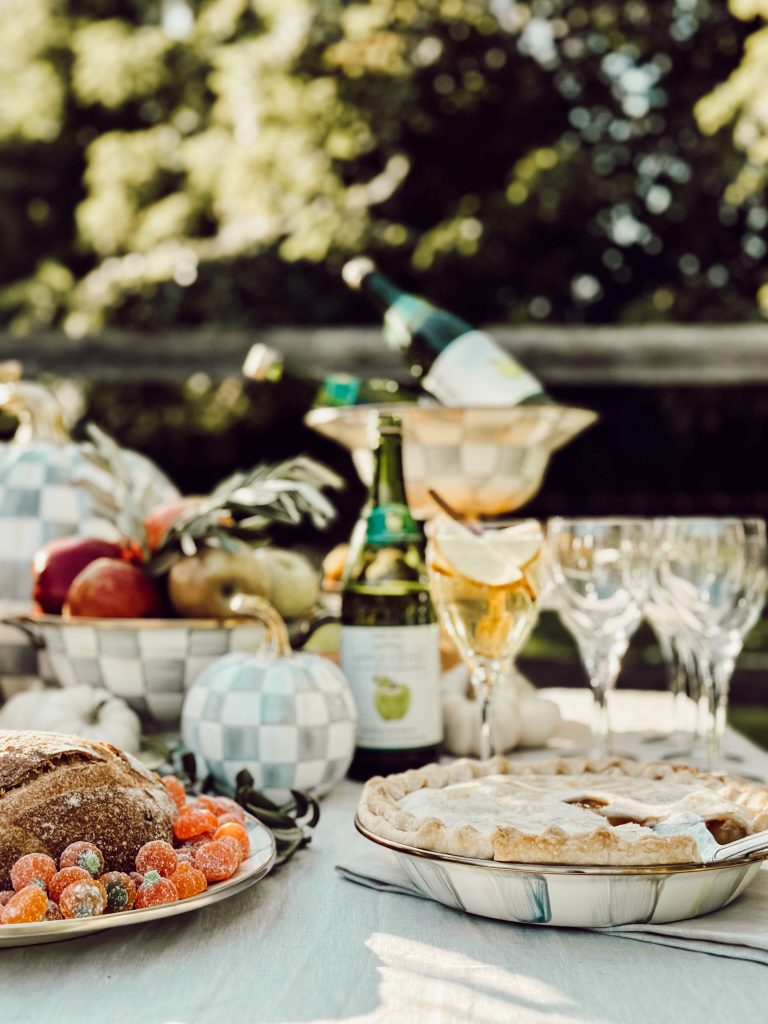 Backyard entertaining in the fall with apple pie, a charcuterie board, and sparkling apple cider.