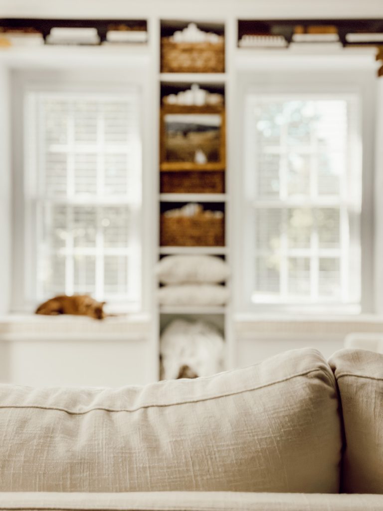 Cozy living room for fall with warm toned baskets soft throws, and throw pillows.