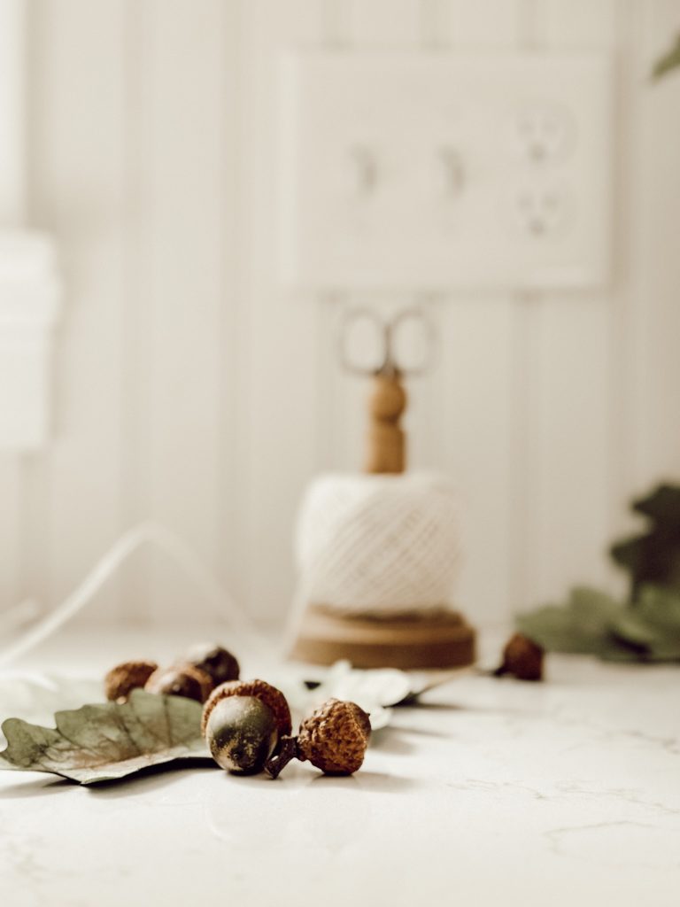 Kitchen twine, acorns, and cardstock leaves for a handmade fall garland.
