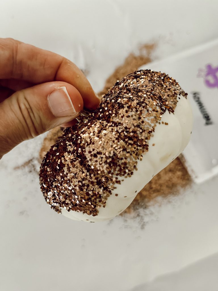 Apply brown glitter to a small white pumpkin with Mod Podge.